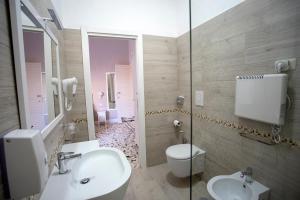 een badkamer met een toilet, een wastafel en een spiegel bij Agorà Mura Greche B&b in Napels +29 foto's