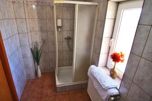 um chuveiro com uma porta de vidro na casa de banho em City Center Apartments & Suites by RDC em Bucareste