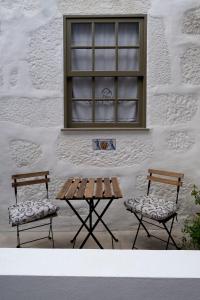 two benches and a table in front of a building at J3M Houses in Porto