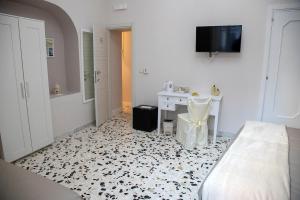 een kamer met een bed, een wastafel en een bureau bij Agorà Mura Greche B&b in Napels