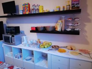 un estante con microondas y platos de comida en B&B La Luce - Casa di Ale, en Loreo
