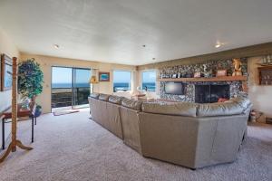 a living room with a large couch and a fireplace at Ocean Breeze in Fort Bragg