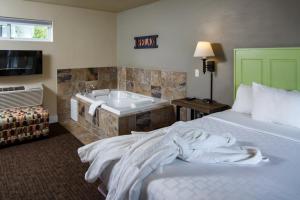 um quarto de hotel com uma cama e uma banheira em Julie's Park Cafe & Motel em Fish Creek