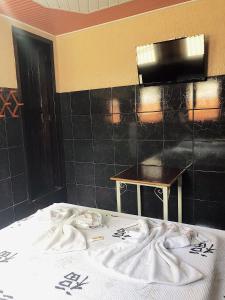 a bedroom with a bed and a table in it at Hotel Fortaleza III Manaus in Manaus