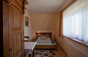 a small bedroom with a bed and a window at Apartamenty-Wynajem pokoi Zbigniew Tylka in Kościelisko