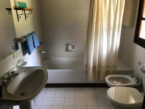 La salle de bains est pourvue d'un lavabo, d'une baignoire et de toilettes. dans l'établissement Posada del Angel, à San Carlos de Bariloche