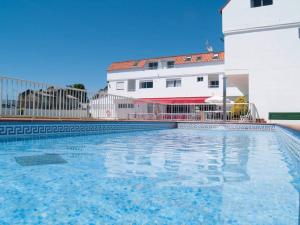 a large swimming pool in front of a building at Camping Playa América Nigrán in Playa América