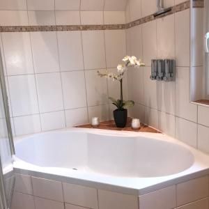 una vasca bianca in bagno con vaso di fiori di Ferienwohnung Stargardt Eimbeckhausen a Bad Münder am Deister Altre 10 foto