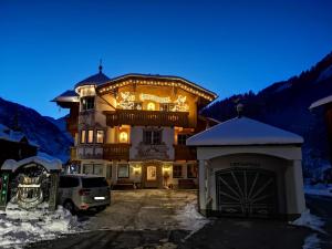 un gran edificio con un coche aparcado delante de él en Ferienschlössl Harmonie en Holzgau