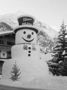 a snowman statue in front of a building at Ferienschlössl Harmonie in Holzgau