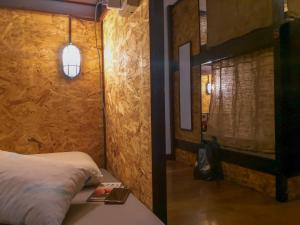 um quarto com uma cama e uma parede de pedra em Spinning Cat Hostel em Tagbilaran