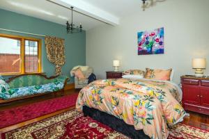1 dormitorio con cama, sofá y ventana en The Sanctuary Beach Side and Spa en Timaru