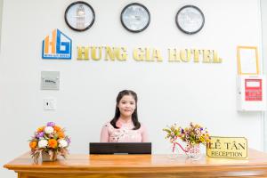a woman standing behind a desk with a laptop at HUNG GIA HOTEL in Quy Nhon
