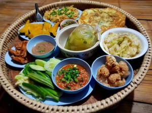 KowitFarmstay في Ban Mae Pan Noi: طبق من الطعام مع مختلف الأطعمة على الطاولة
