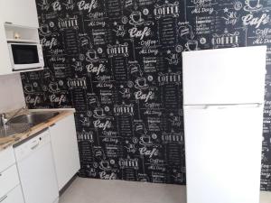 ヴィラ・ノヴァ・デ・ガイアにあるOporto Vasconcelos Guest Houseの黒と白の壁紙を使用したキッチン(冷蔵庫付)