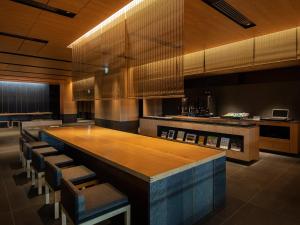 Tokyu Stay Kyoto Sakaiza Shijo Kawaramachi في كيوتو: مطبخ كبير مع طاولة وكراسي خشبية كبيرة