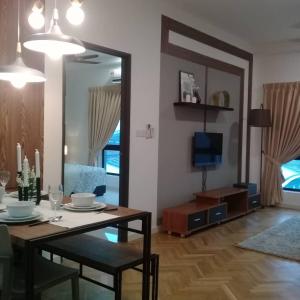 a living room with a dining table and a television at Adore Homestay@Emira Seksyen 13 Shah Alam, MSU, Stadium, AEON Mall in Shah Alam