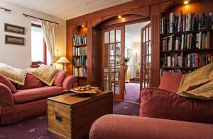 a living room with two couches and bookshelves at Dunhallin House in Inverness