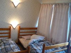 two twin beds in a room with a window at Fureai No Yado Yasuragi in Nozawa Onsen