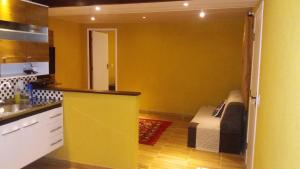 a kitchen with a couch and a yellow wall at Vista Magnata in Domingos Martins