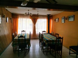 a dining room with two tables and chairs and a window at Hotel Ventura in Chile Chico
