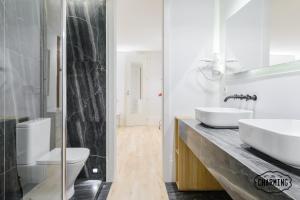 een badkamer met 2 wastafels en een glazen douche bij Charming Ribera de Curtidores in Madrid