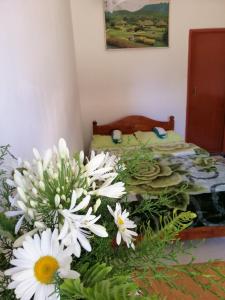 a bed with a bunch of white flowers in a room at The Galways Edge Homestay in Nuwara Eliya