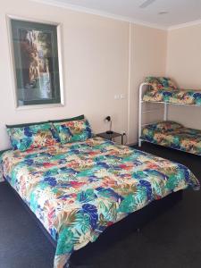 a bedroom with a bed with a colorful comforter at Wentworth Central Motor Inn in Wentworth