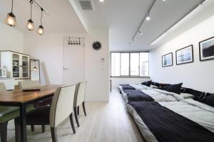 a dining room with a long bed and a table at Culinary Bed&Art 401 in Hamamatsu