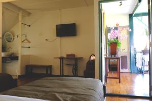 a bedroom with a bed and a tv on the wall at Pimthong Place in Bangkok