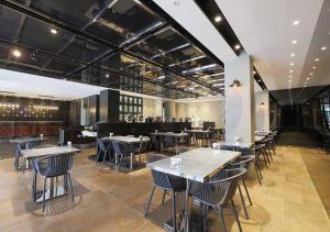 a restaurant with tables and chairs and a bar at Royal Group Hotel Bo Ai Branch in Kaohsiung