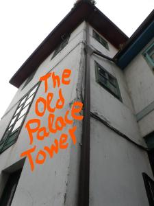 an orange sign on the side of a building at The Old Palace Tower / La Torre del Palación in Cudillero