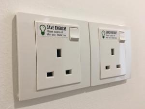 two white electrical switches are attached to a wall at Signel Hostel in Kota Kinabalu