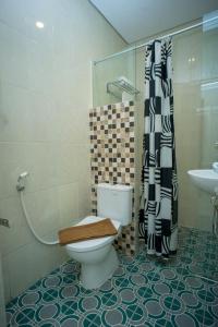 a bathroom with a toilet and a shower and a sink at Zoom Hotel Mulawarman in Samarinda