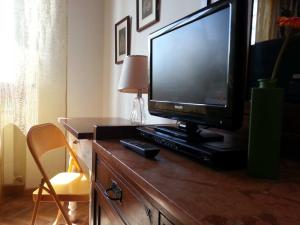 a television sitting on top of a wooden dresser at A Due Passi Dal Centro Bed and Breakfast in Pisa