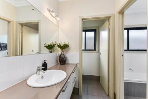 un bagno con lavandino e specchio di Accommodation On Lansell 1 being Unit 1 of 6 Lansell Street a Mount Gambier Altre 8 foto