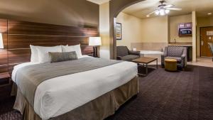 a hotel room with a large bed and a bathroom at Best Western Plus Hill Country Suites - San Antonio in San Antonio