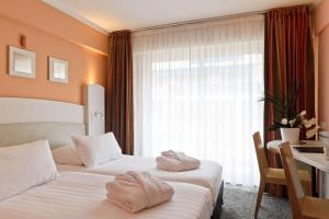 two towels on two beds in a hotel room at Best Western Astoria in Juan-les-Pins