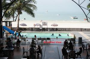 a swimming pool with a beach in the background at Best Star Resort in Pantai Cenang