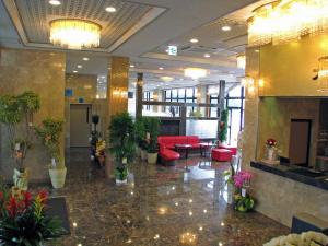 een lobby met rode meubels en planten in een gebouw bij Hotel Nami in Kumano