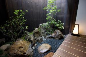 un jardín con rocas y plantas y una valla de madera en Anzu an Machiya House, en Kioto