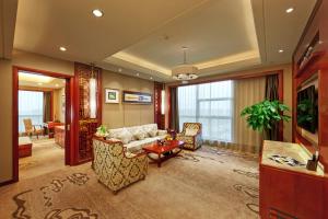 a living room with a couch and a table at Empark Grand Hotel Hangzhou Bay Ningbo in Ningbo