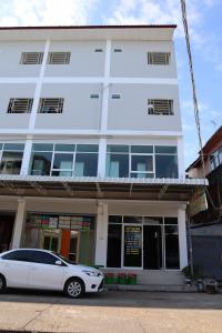 biały samochód zaparkowany przed budynkiem w obiekcie SKF Apartment w mieście Sakon Nakhon