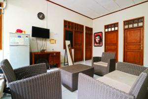 a living room with chairs and a table and a tv at Premium Senen Guesthouse - Female Only in Jakarta