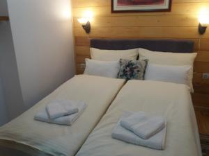 a large white bed with two folded towels on it at Apartments Vila Zubović in Kopaonik