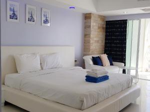 a white bedroom with a bed and a couch at View Talay 6 Pattaya Beach by CANDO in Pattaya Central