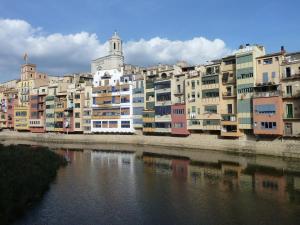 eine Gruppe von Gebäuden neben einem Wasserkörper in der Unterkunft Girona Riverside in Girona