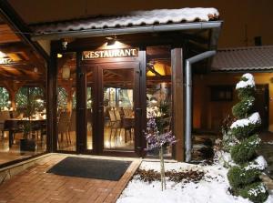 a restaurant with its doors open in the snow at Penzión BEBEK in Fiľakovo