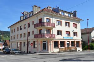 Un gran edificio blanco en la esquina de una calle. en Appartement Timgad, en Gérardmer