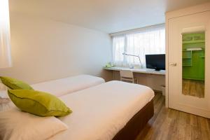 a hotel room with two beds and a desk at Campanile Montluçon ~ Saint-Victor in Saint-Victor